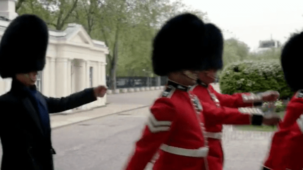 Sherlock borrows a hat and marches in time with the other guardsmen to sneak past the window. 